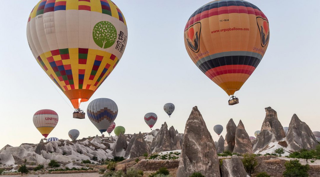 Sejumlah wisatawan terbang menaiki balon udara panas di atas Nevsehir di wilayah Cappadocia, Turki (5/9). Balon udara panas yang terbang di atas Cappadocia juga menjadi pemandangan menarik bagi para wisatawan. (AFP Photo/Yasin Akgul)